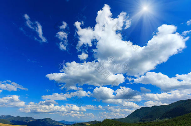 蓝色的阳光明媚的天空，山上有白云。