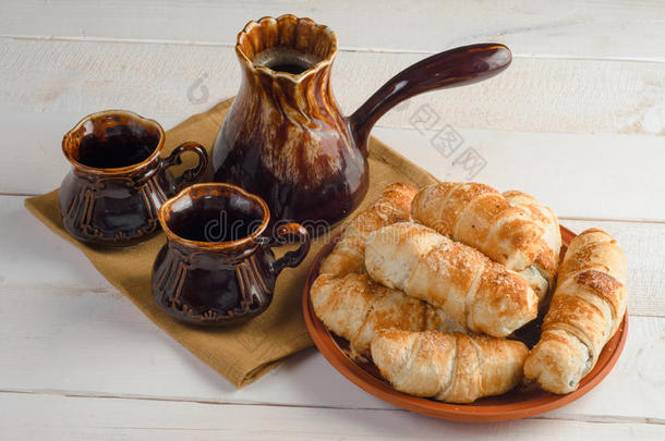 咖啡组合物与牛角面包，设置在木桌上