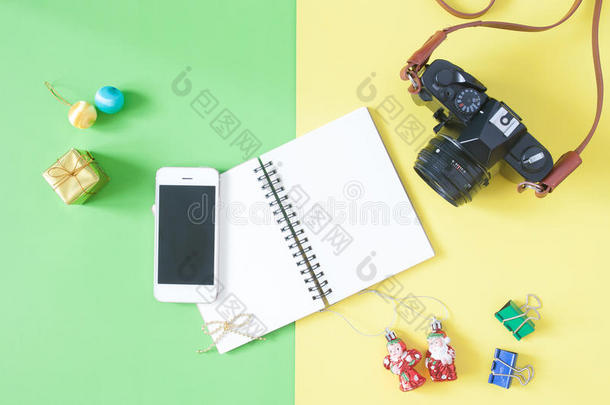 平躺的空笔记本与智能手机，相机和圣诞节