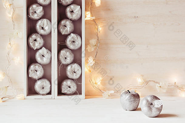 圣诞软<strong>家居</strong>装饰的银苹果和<strong>灯</strong>燃烧在盒子在一个木制的白色背景。