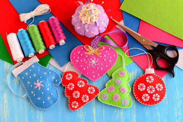 圣诞树装饰工艺品。手感粉红的心，红绿相间的圣诞树，蓝色的手套，木质背景上的红色球
