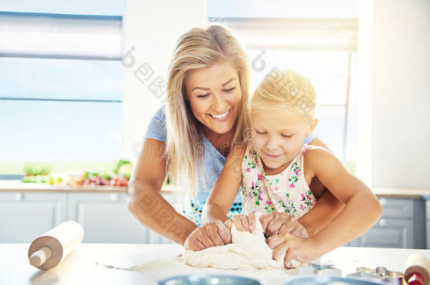 崇拜年轻的母亲教她的女儿烘焙