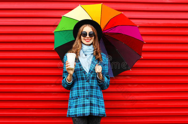 <strong>时尚</strong>漂亮的年轻微笑的女人带着<strong>五</strong>颜六色的雨伞咖啡杯，穿着一件红色的<strong>黑</strong>色帽子外套