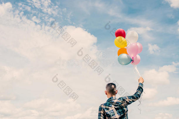 快<strong>乐</strong>的年轻潮人背在草原上拿着五颜六色的气球，<strong>享</strong>受<strong>生活</strong>和快<strong>乐</strong>。