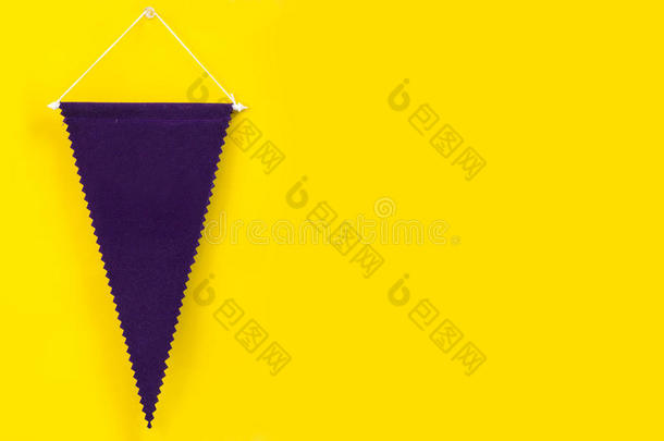 悬挂在黄色墙上的深紫色<strong>旗</strong>帜