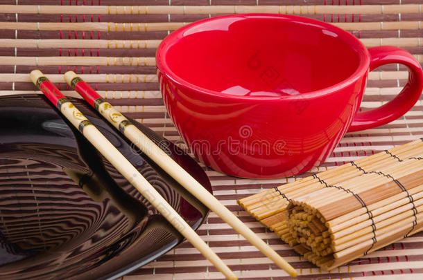 空杯子和寿司筷子在空盘子上
