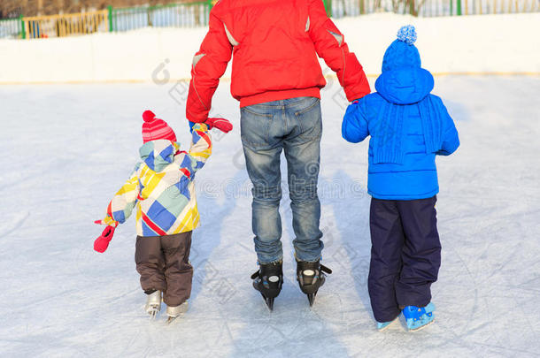 父亲带着两个孩子滑冰，家庭冬季运动