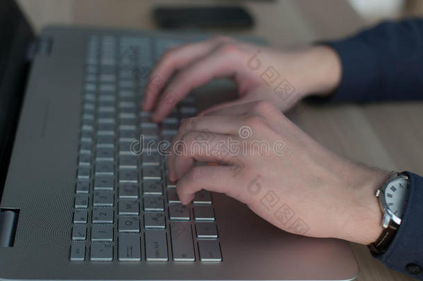 双手在笔记本电脑键盘上打字。 在工作场所工作的人