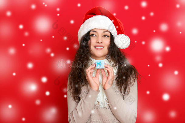 女孩在圣诞帽肖像与<strong>小礼品</strong>盒摆在红色背景，圣诞节假日概念，快乐和情感