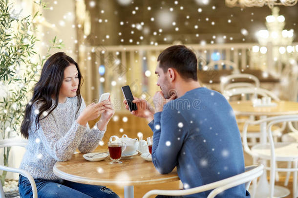 一对夫妇用智能手机在咖啡馆喝茶