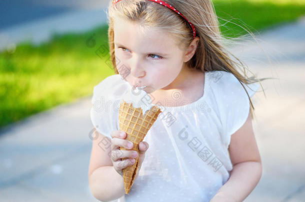 可爱的小女孩在温暖阳光明媚的夏日公园吃美味的冰淇淋