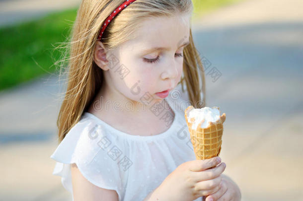 可爱的小女孩在温暖阳光明媚的<strong>夏日</strong>公园吃美味的<strong>冰淇淋</strong>