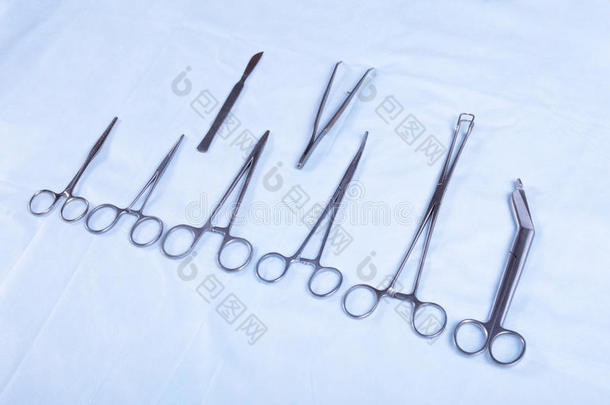 白色背景下四种不同不锈钢手术钳和手术刀的特写镜头