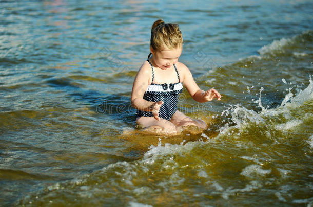可爱的小女孩正在溅水，打碎海水，玩得很开心
