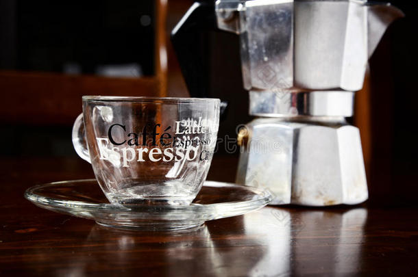 深色木制桌子上的玻璃咖啡杯和老式咖啡壶