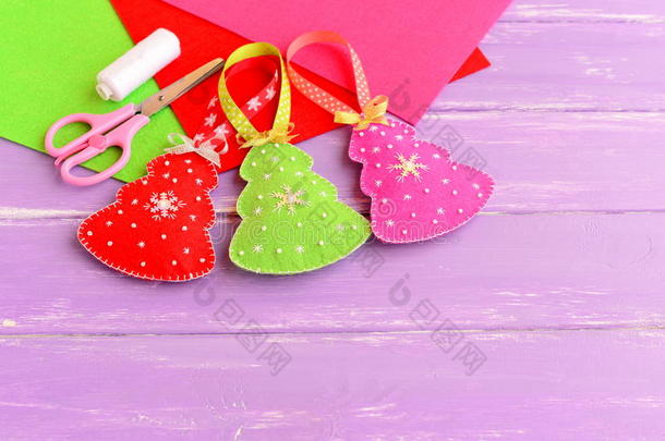 绿色，红色和粉红色圣诞树工艺品，剪刀，白线，针，毡<strong>床单</strong>设置在丁香木背景