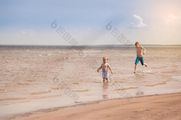 孩子们沿着海滩奔跑，用<strong>水溅起水</strong>花