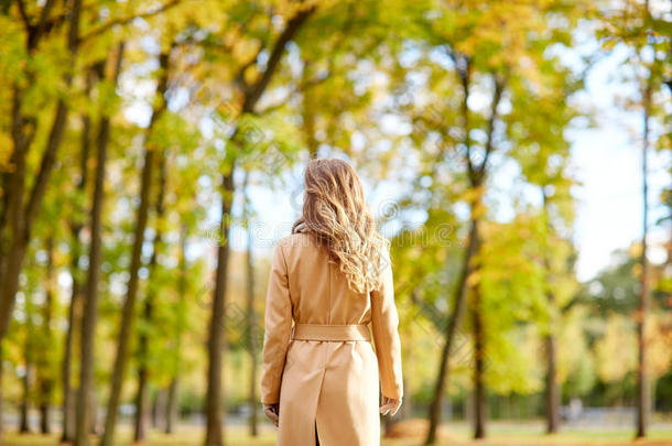 美丽的年轻女子漫步在秋天的公园里