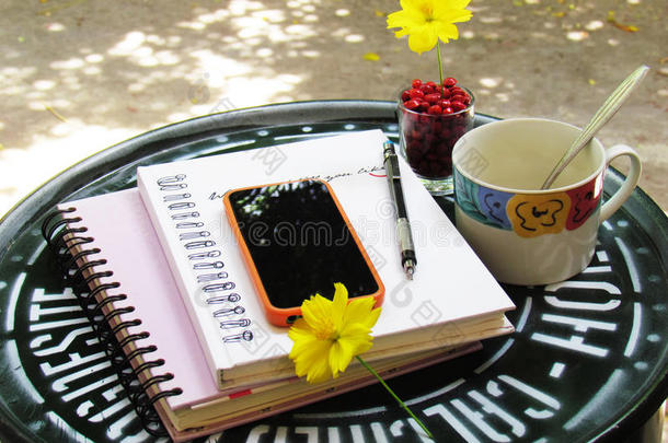 咖啡杯，笔记本，铅笔和绿色钢制桌子上的花<strong>自己做</strong>。 角落放松的概念。