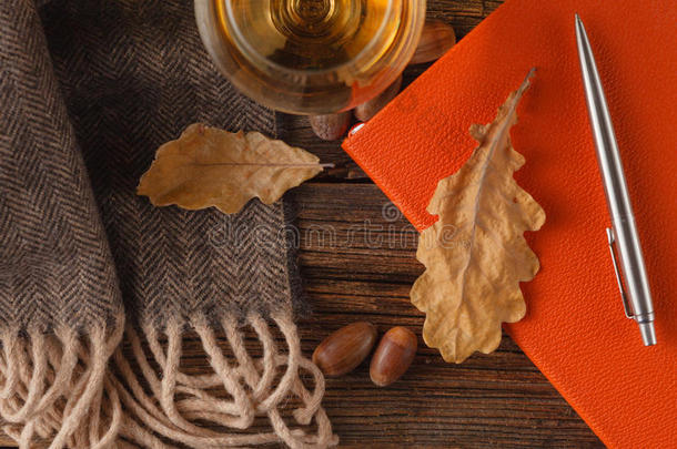 秋天的枫叶和羊毛围巾在木制的背景上。 秋天的背景。