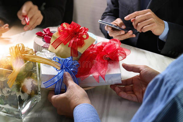 礼品赠送创意手使用智能手机和同事选择礼物。 送礼物，办公室派对，大理石会议