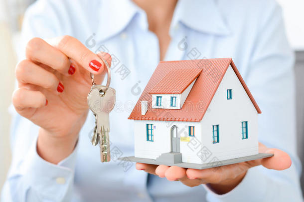 女人手拿样板房和钥匙买房子的概念