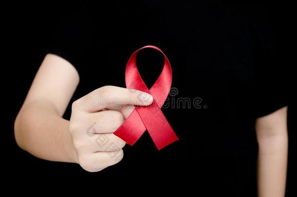 手拿着红色丝带在世界艾滋病的黑色背景标志d