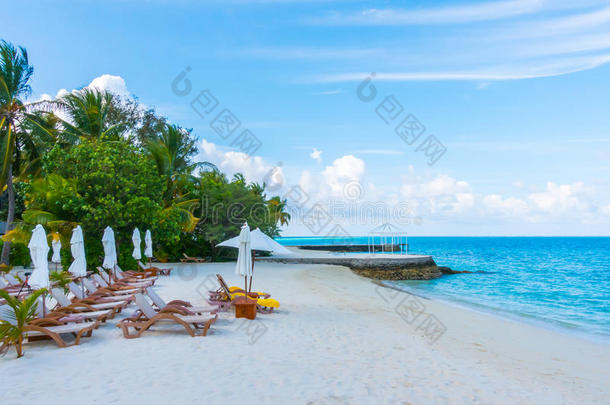 海滩椅子与伞在马尔代夫岛与白色桑迪