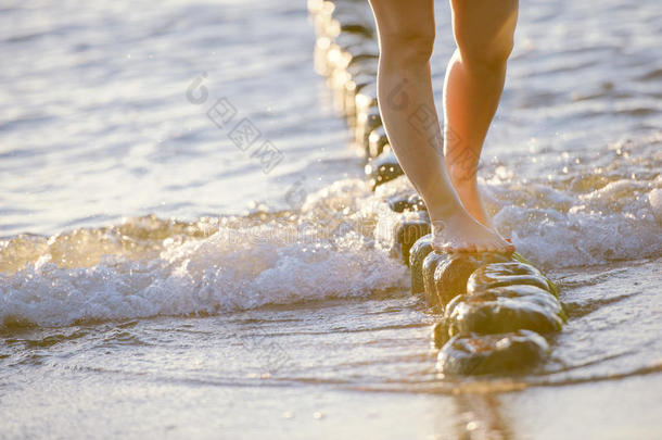 在阳光明媚的夏日，脚在阳光明媚的海滩上特写。