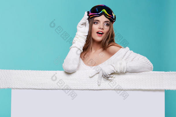 美丽的冬天的女人拿着一块空白的广告牌