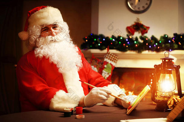 圣诞节的概念。 圣诞老人做玩具，特写。 木制桌子上的圣诞装饰品