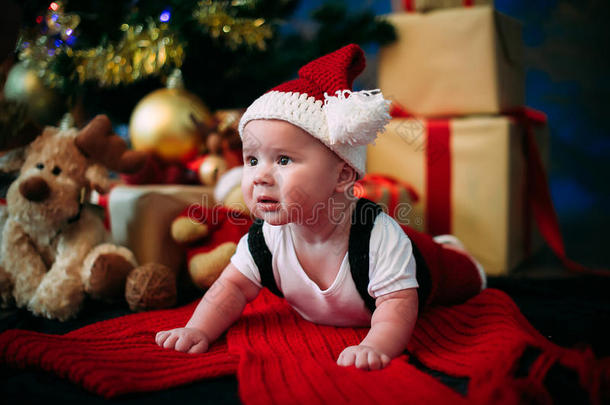 童话般的肖像圣诞可爱的小婴儿穿着像圣诞老人在新年背景下的树