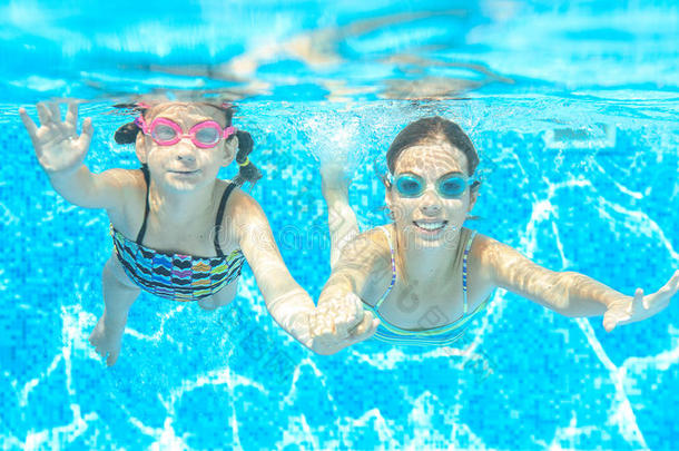 孩子们在水下游泳池里游泳，快乐的活跃女孩在护目镜中玩得开心，孩子们在运动