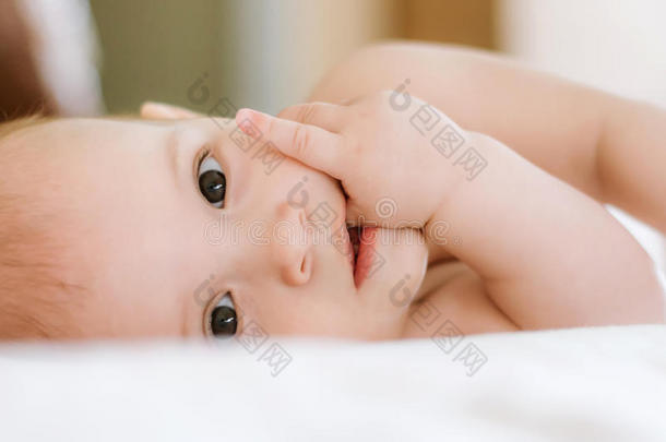 婴儿躺在它的一边，吮吸一根手指