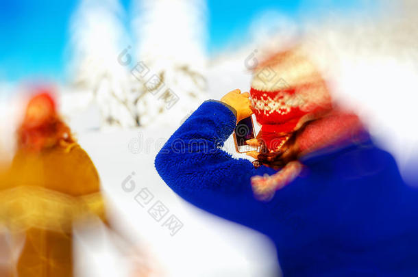 一个男人在美丽的山上雪景中的女孩照片。 模糊效果。