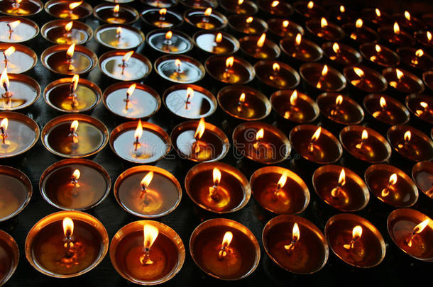 圣诞蜡烛在晚上燃烧。 抽象蜡烛背景。 蜡烛火焰的金光。