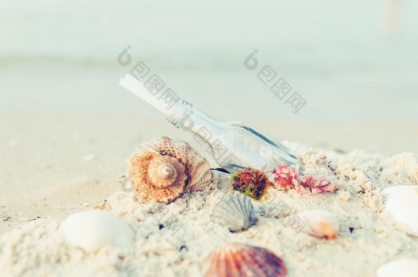 瓶子上有<strong>留言</strong>或信件，在海滩上靠近贝壳。 索斯。 复制空间。