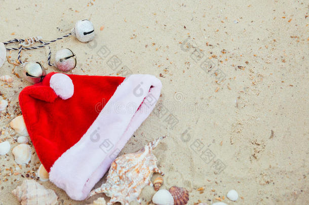 海滩上的圣诞帽。 在贝壳附近的沙子上圣诞老人。 假期。 新年假期。 复制空间。 框架。 上面的风景。