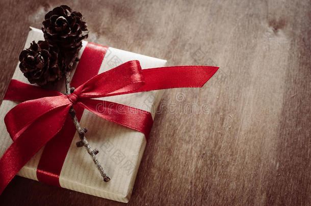 圣诞卡夫盒与礼物，绑在红色丝带和松果在乡村风格。