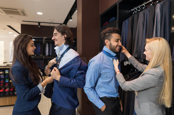 英俊的商人尝试服装女人时装店，顾客选择在<strong>零售店</strong>