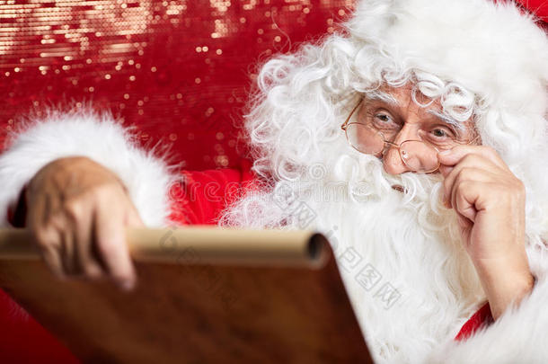 检查他的特别名单。 传统的圣诞老人坐着