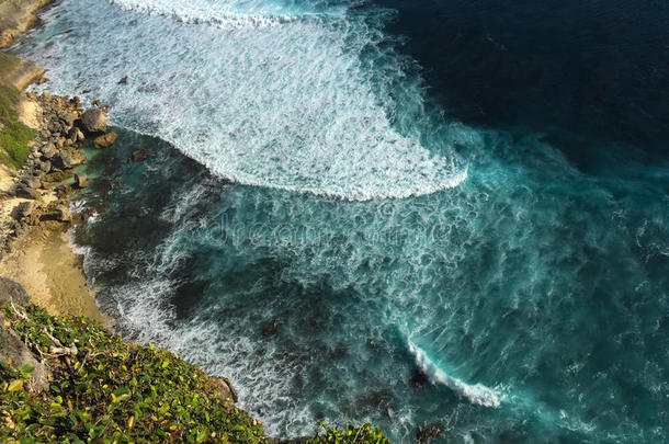 蓝色的海浪从海洋中卷曲，溅在黄沙滩上。 热带海洋危险。