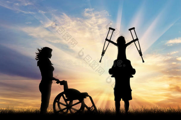 残疾的孩子站在父亲的肩膀上，拿着拐杖和轮椅护士日落