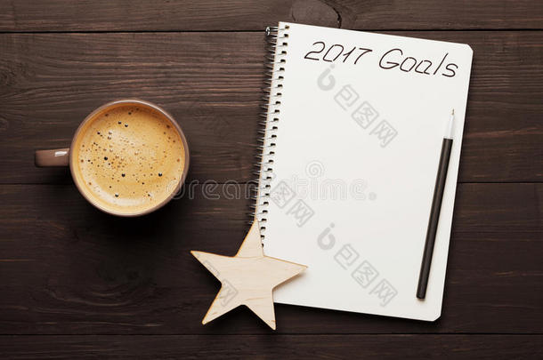 一杯咖啡和笔记本，2017年的目标是从上面的木桌上。 新年概念的规划和动机。