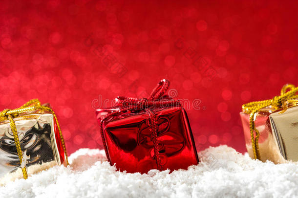 圣诞<strong>礼盒装</strong>饰在雪和红色闪光的背景上