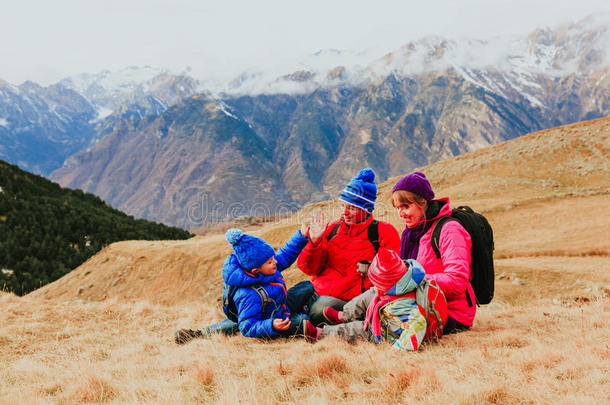 有两个孩子的家庭在风景优美的冬季山区旅行