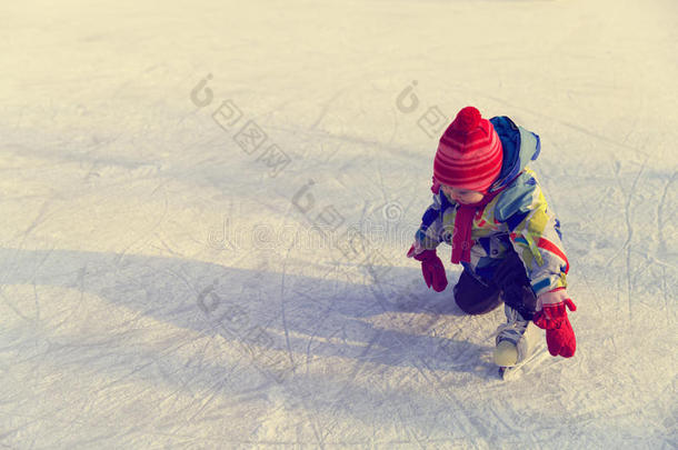 可爱快乐的小女孩在冬天学会滑冰