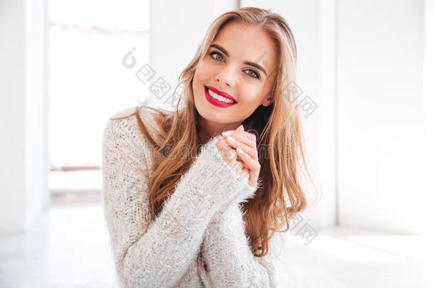 开朗的微笑女孩涂着红色的口红和白色的毛衣