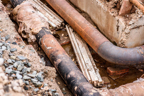 挖掘坑。 旧的饮用水管道与不锈钢修复套筒成员。 完成修理的管道等待