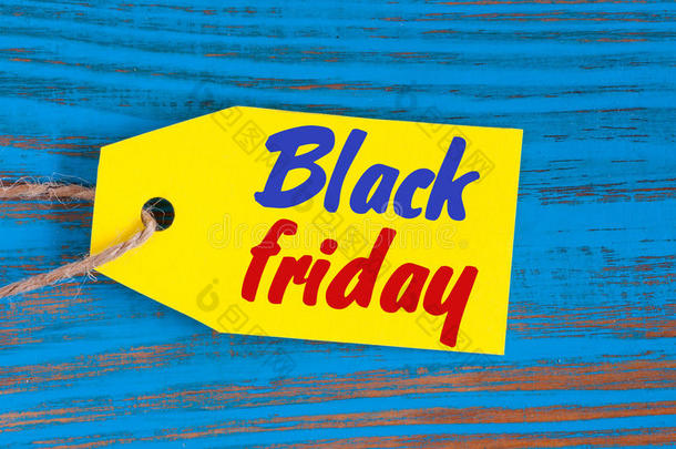 黑色星期五销售标签在蓝色木制背景。 销售，折扣，广告，销售价格标签的衣服